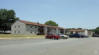 A parking lot with cars and a building in the background.